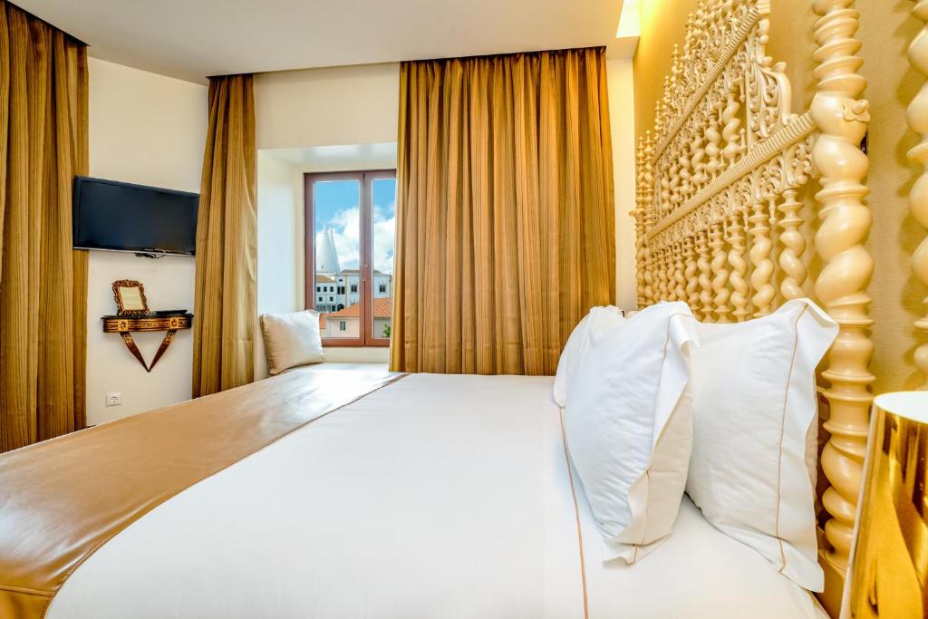 a hotel room with a large bed and a window at Sintra Boutique Hotel in Sintra