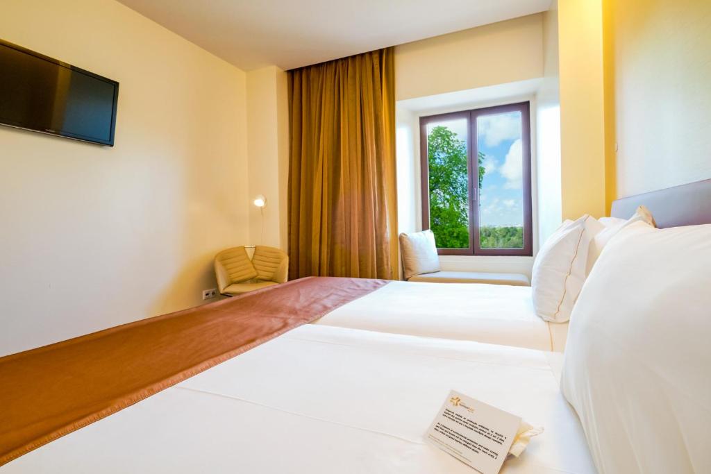 a hotel room with two beds and a window at Sintra Boutique Hotel in Sintra