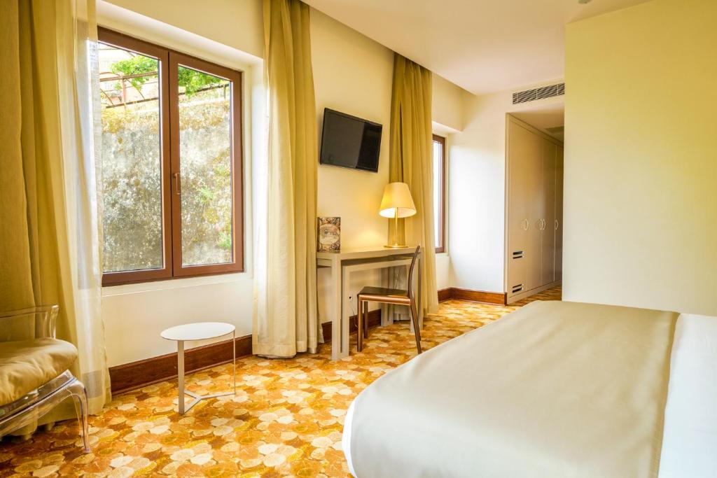 a bedroom with a bed and a desk and a window at Sintra Boutique Hotel in Sintra
