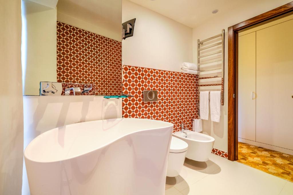 a bathroom with a white tub and a toilet at Sintra Boutique Hotel in Sintra