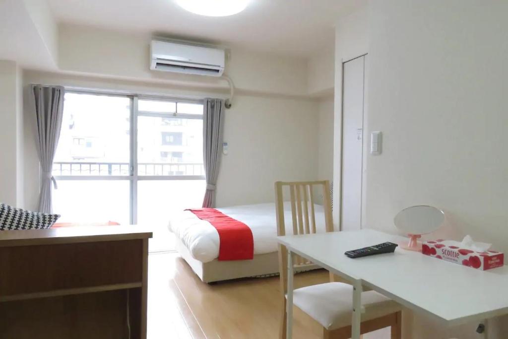 um quarto com uma cama, uma secretária e uma mesa em Saint Million Tenjin - Vacation STAY 93047 em Fukuoka