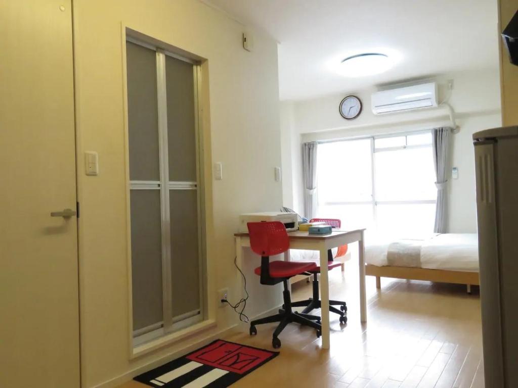 Zimmer mit einem Schreibtisch, einem Stuhl und einem Bett in der Unterkunft Saint Million Tenjin - Vacation STAY 93030 in Fukuoka