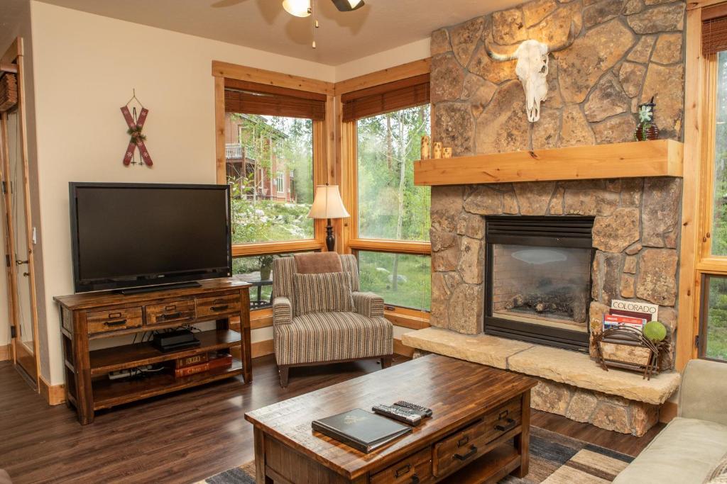a living room with a fireplace and a tv at 6506 Settlers Creek Condo in Keystone