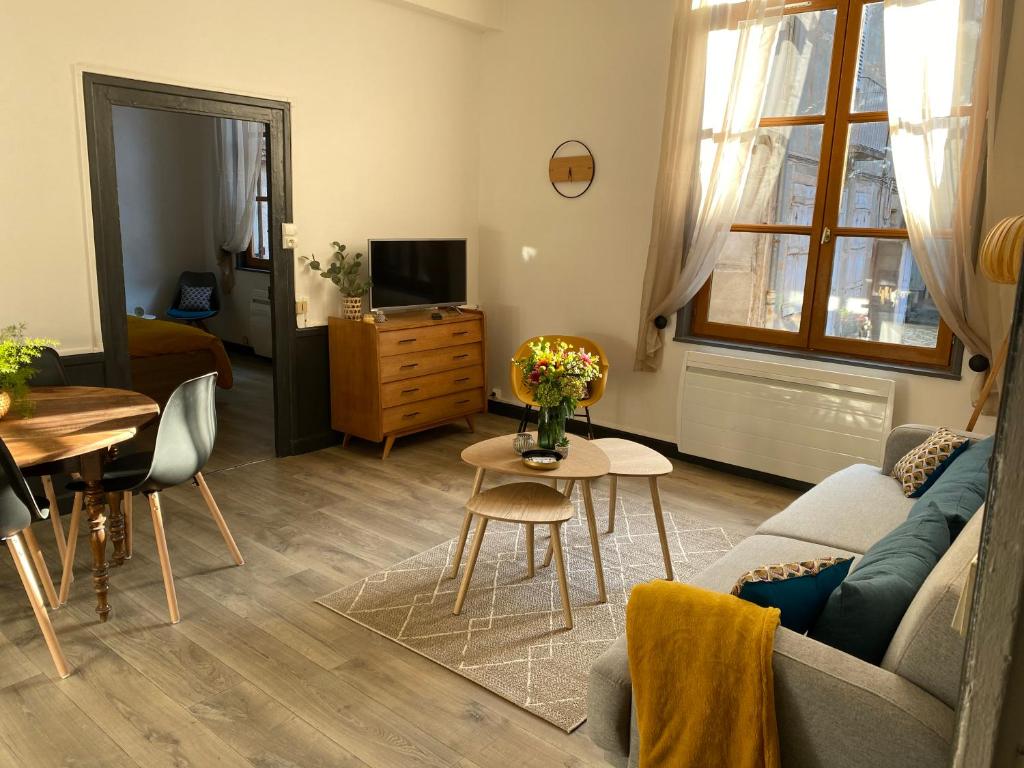 a living room with a couch and a table at joli appartement quartier historique, 5 pers in Moulins