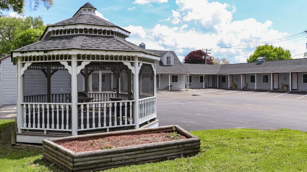 - un kiosque dans une cour devant un bâtiment dans l'établissement Seneca Clipper Inn, à Watkins Glen