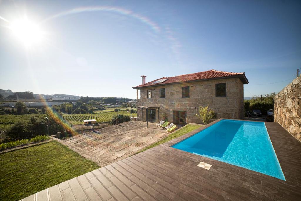 a villa with a swimming pool in front of a house at Quinta da Casa Nova in Santo Tirso