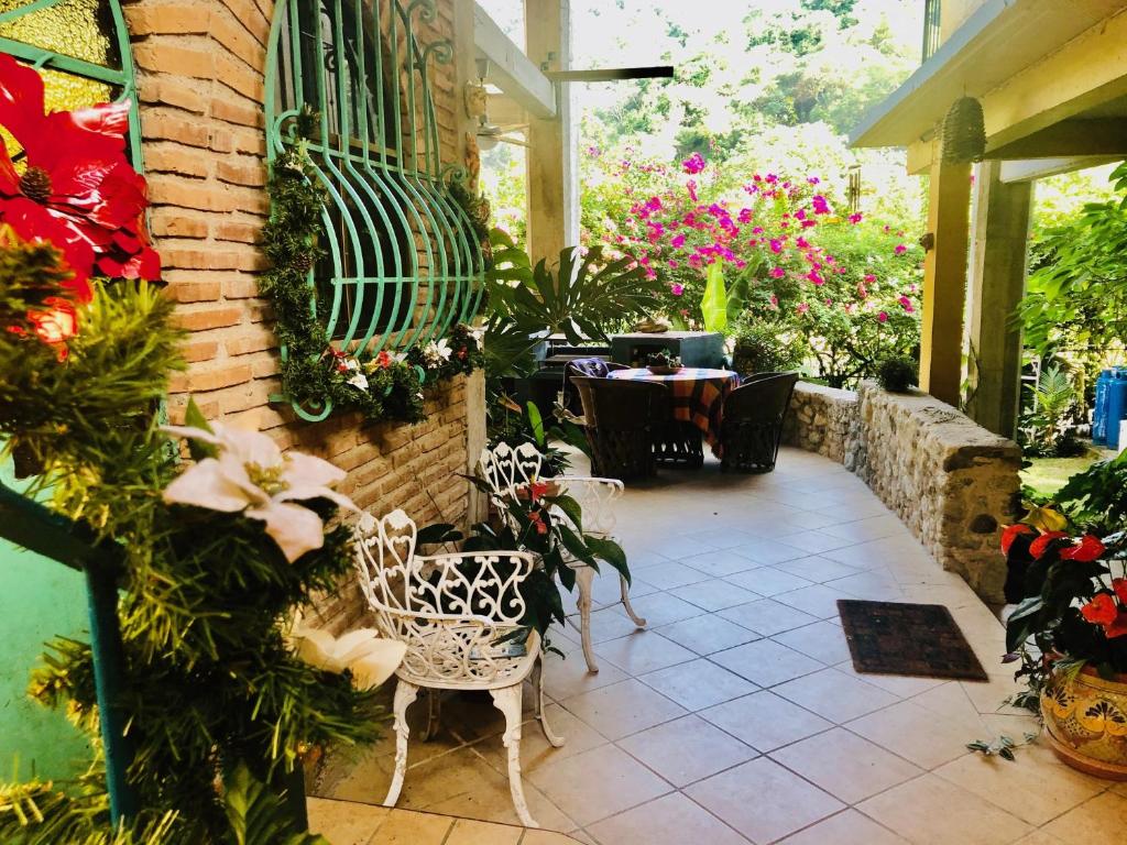 a patio with a table and chairs and flowers at Casa Cereza Apartments in Puerto Vallarta