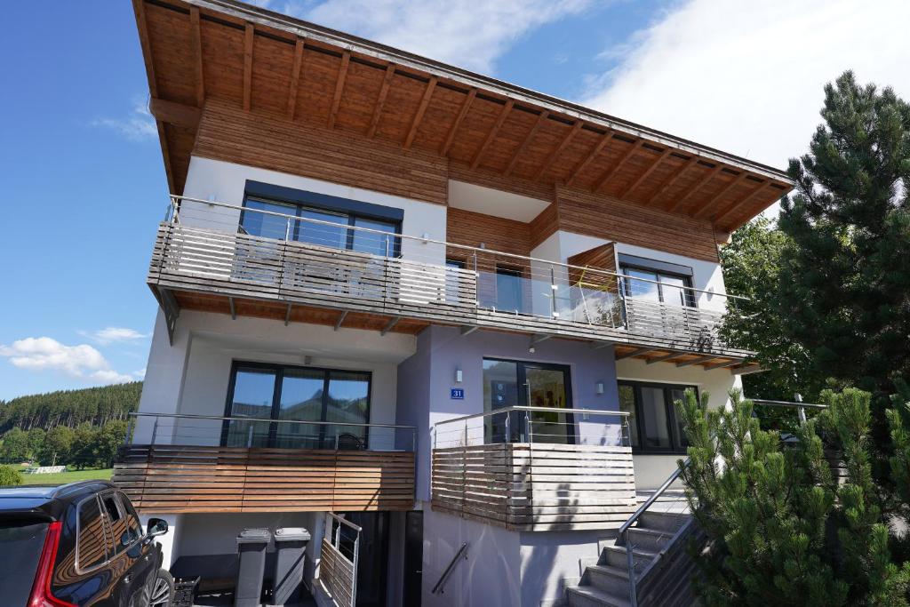 a house with a balcony with a wooden roof at Elinas Mountain Views in Kaprun