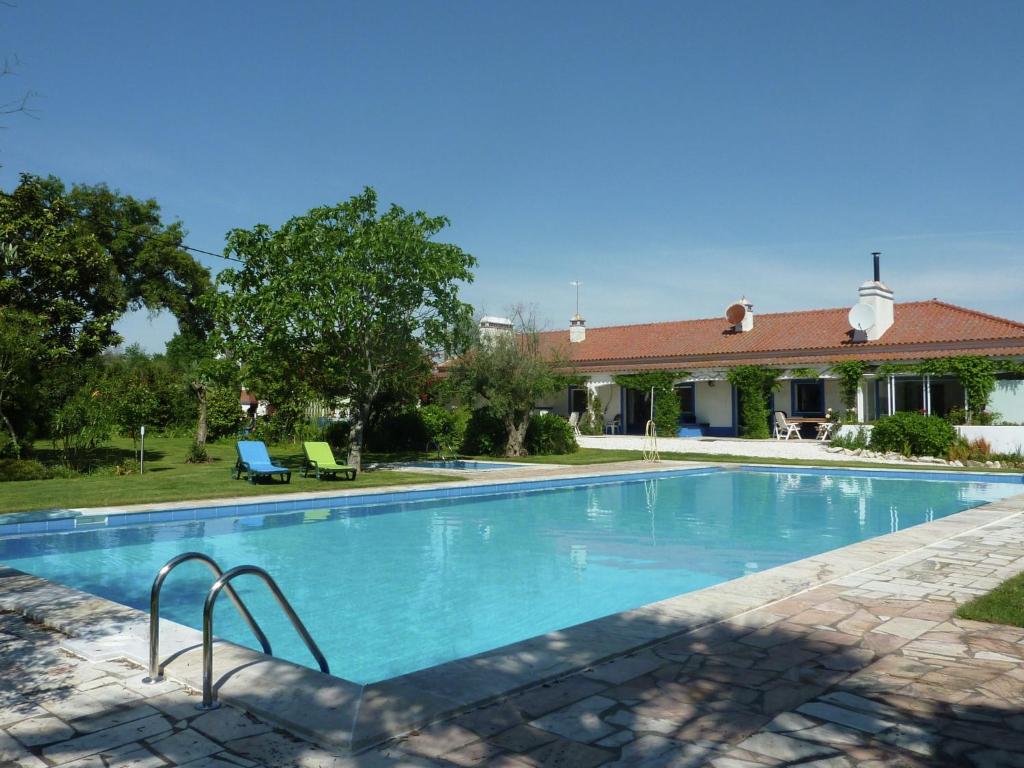 a swimming pool in front of a house at Inviting holiday home in Montemor o Novo with Pool in Montemor-o-Novo