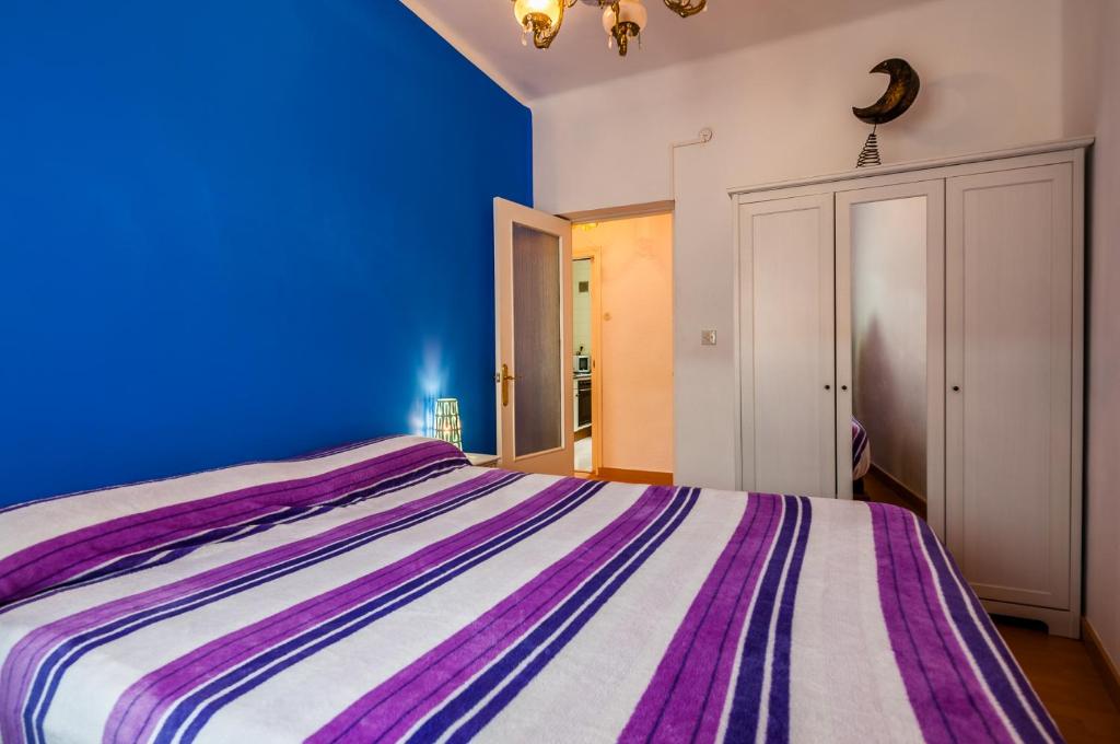 a blue bedroom with a purple and white bed at Santoña Paseo Marítimo 2ª linea playa, Llegada autónoma, Wifi in Santoña