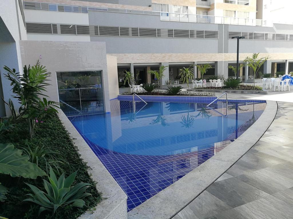 a swimming pool with blue tiles in a building at Park Veredas Apart in Rio Quente