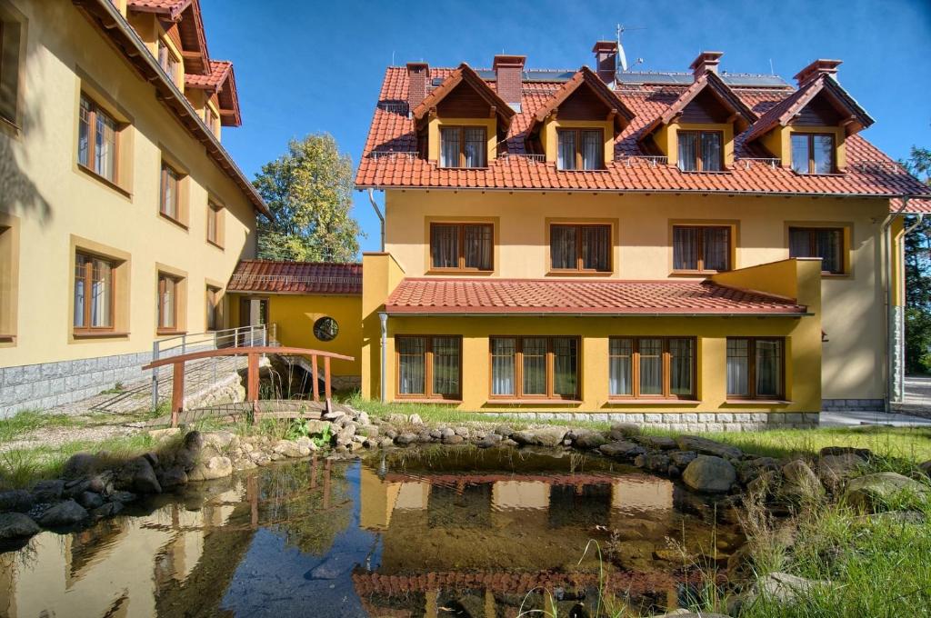 une maison avec une rivière devant elle dans l'établissement Hotel Dobry Klimat, à Szklarska Poręba