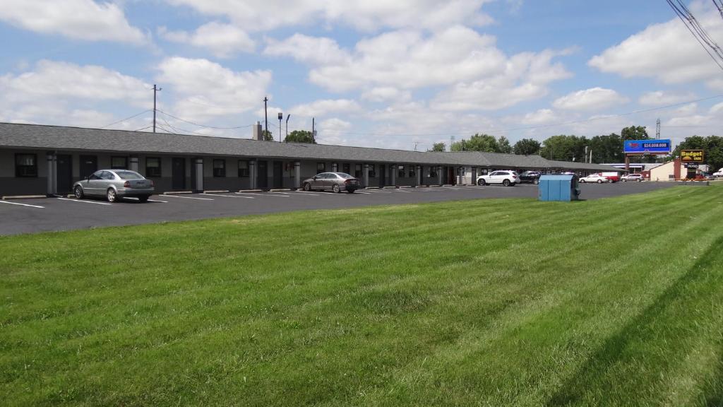 a parking lot with cars parked in front of a building at Budget Inn Columbus in Lockbourne