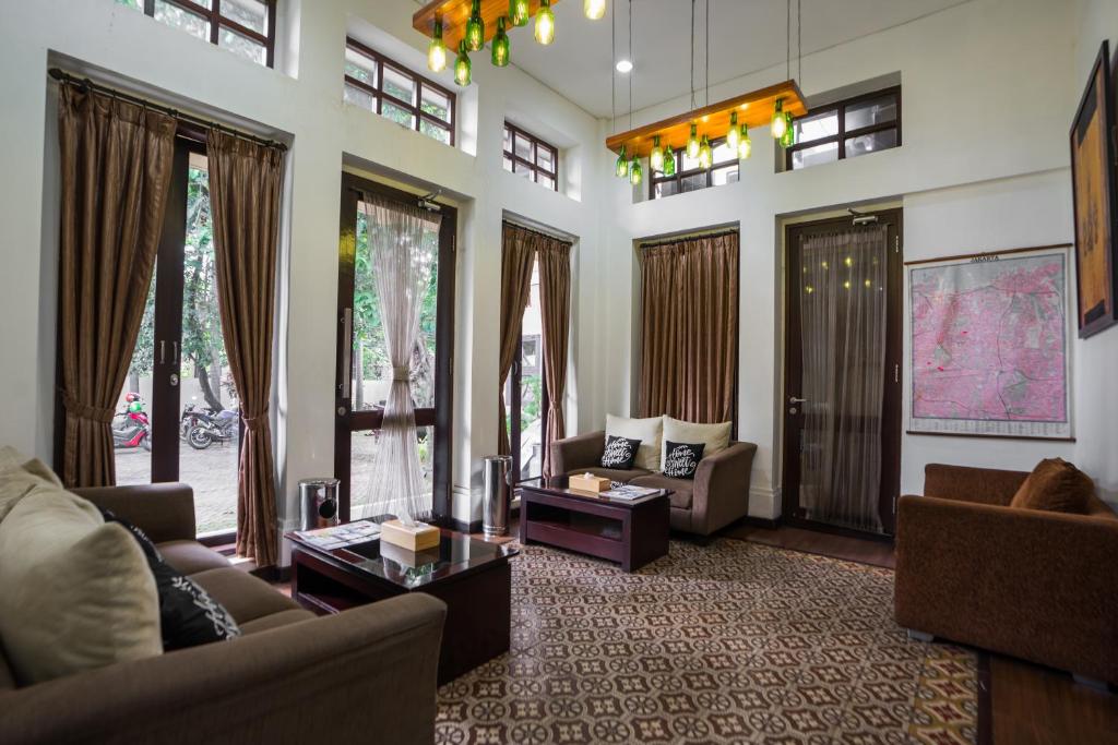雅加達的住宿－ARCS House Menteng by Jambuluwuk，带沙发和桌子的客厅以及窗户。