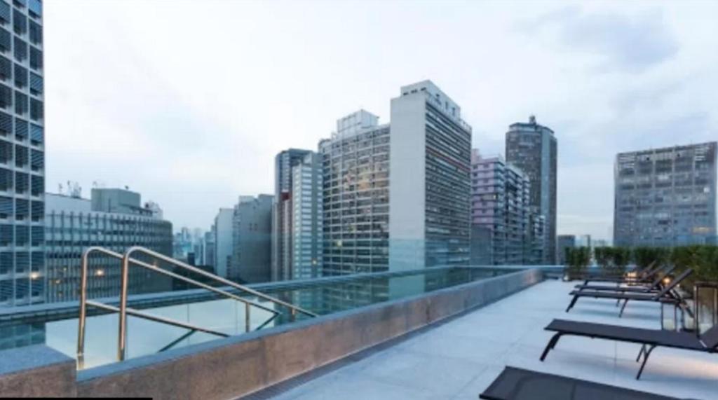 a balcony with a view of a city skyline at Lindo Studio Metrô Anhangabaú in São Paulo