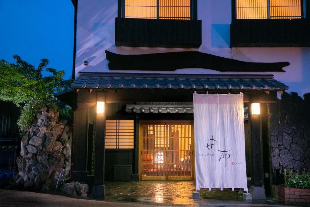 un edificio con una señal delante de él en Yasuraginoyado Yufu, en Beppu