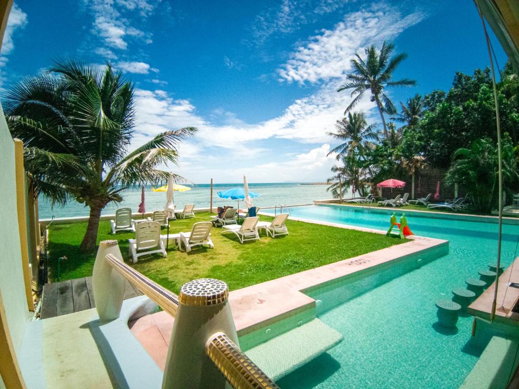 a swimming pool with a view of the ocean at Le Divine Comedie Beach Resort in Baan Tai