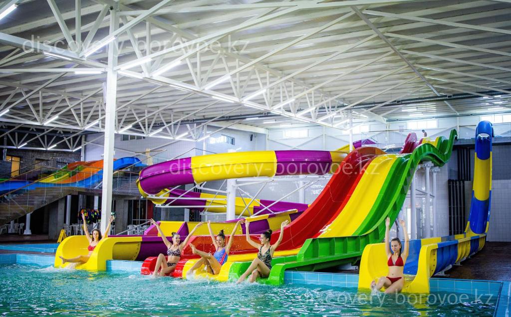 a group of children playing on a water slide in a pool at Discovery-Borovoe in Kotarkol
