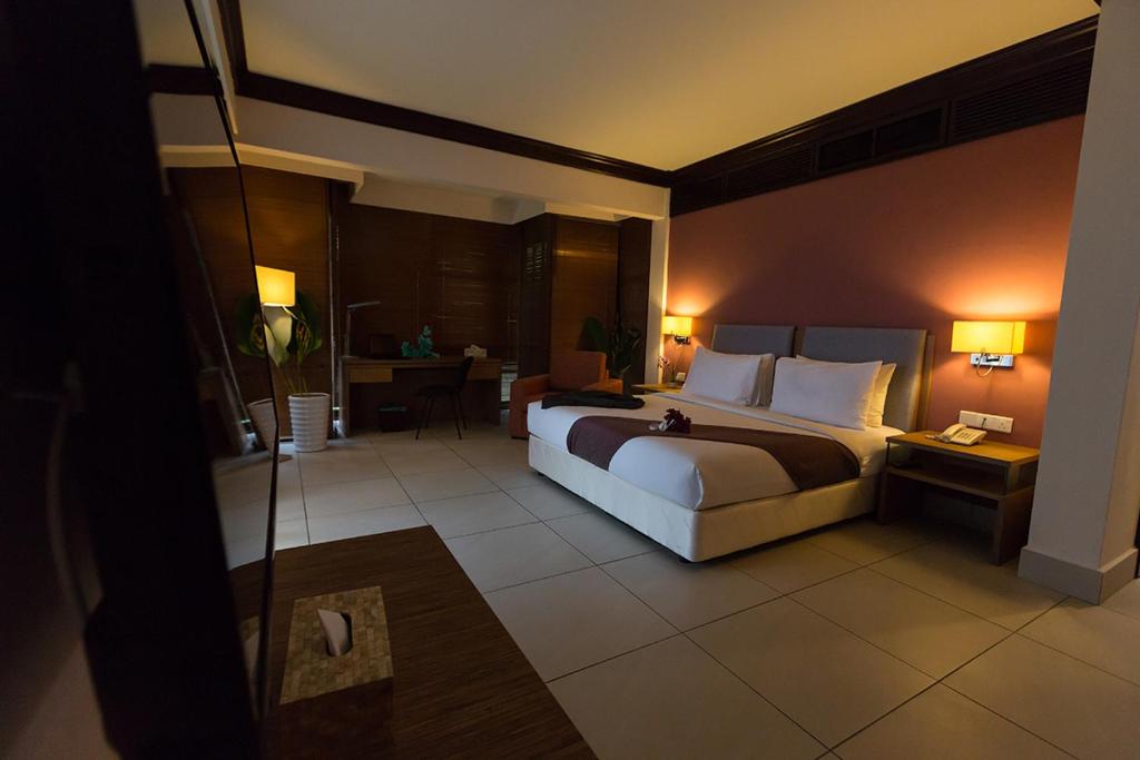 a bedroom with a large bed in a hotel room at Sebana Cove Resort in Pengerang