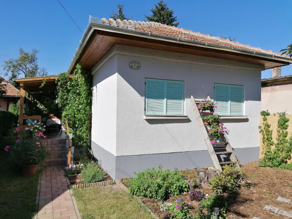 ein weißes Haus mit blauen Fensterläden darauf in der Unterkunft Menta Apartman in Mezőkövesd