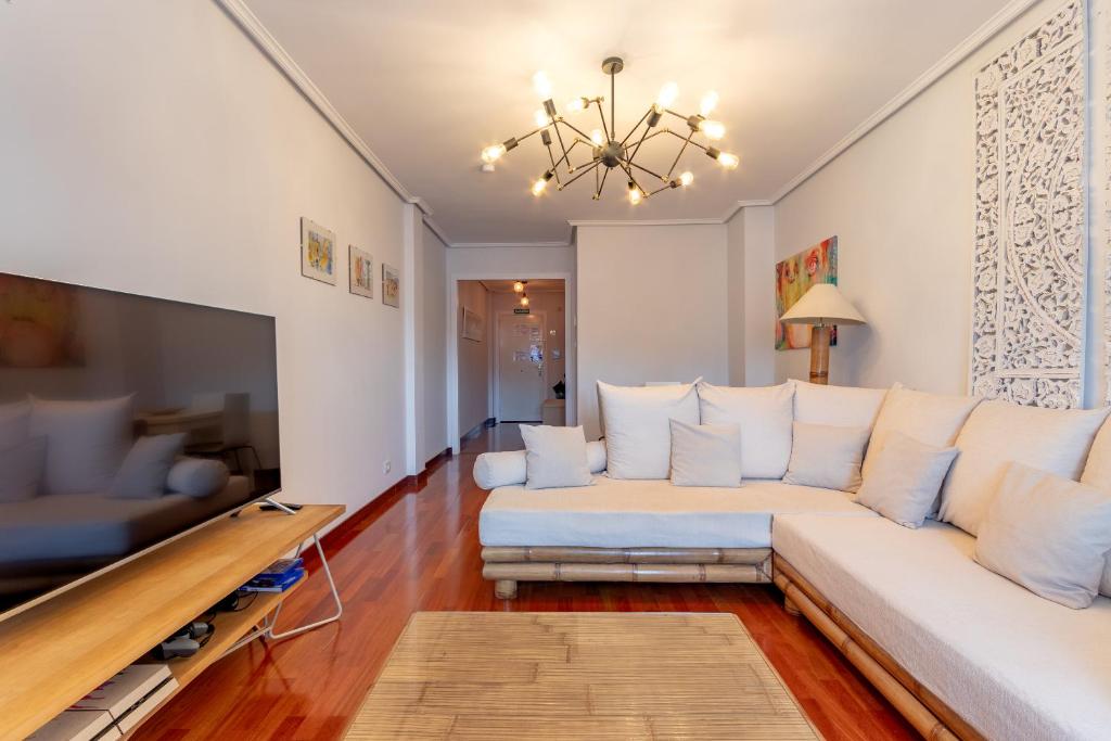 sala de estar con sofá blanco y TV en Precioso apartamento cerca de Bilbao Exhibition Center -BEC-, Bilbao y playas, en Barakaldo