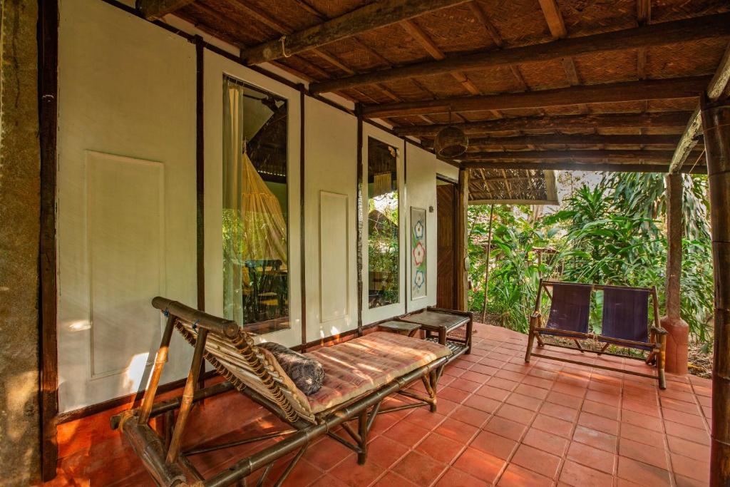 a porch with a hammock on a house at Bhakti Kutir in Palolem