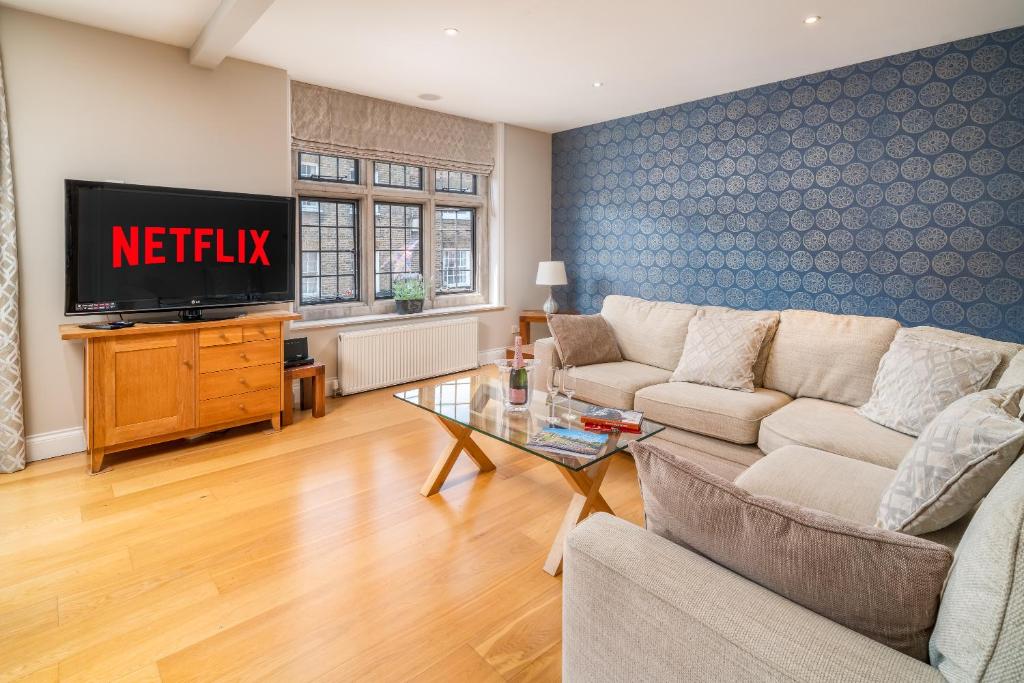 a living room with a couch and a tv at Castle Properties:Eton-The College in Windsor