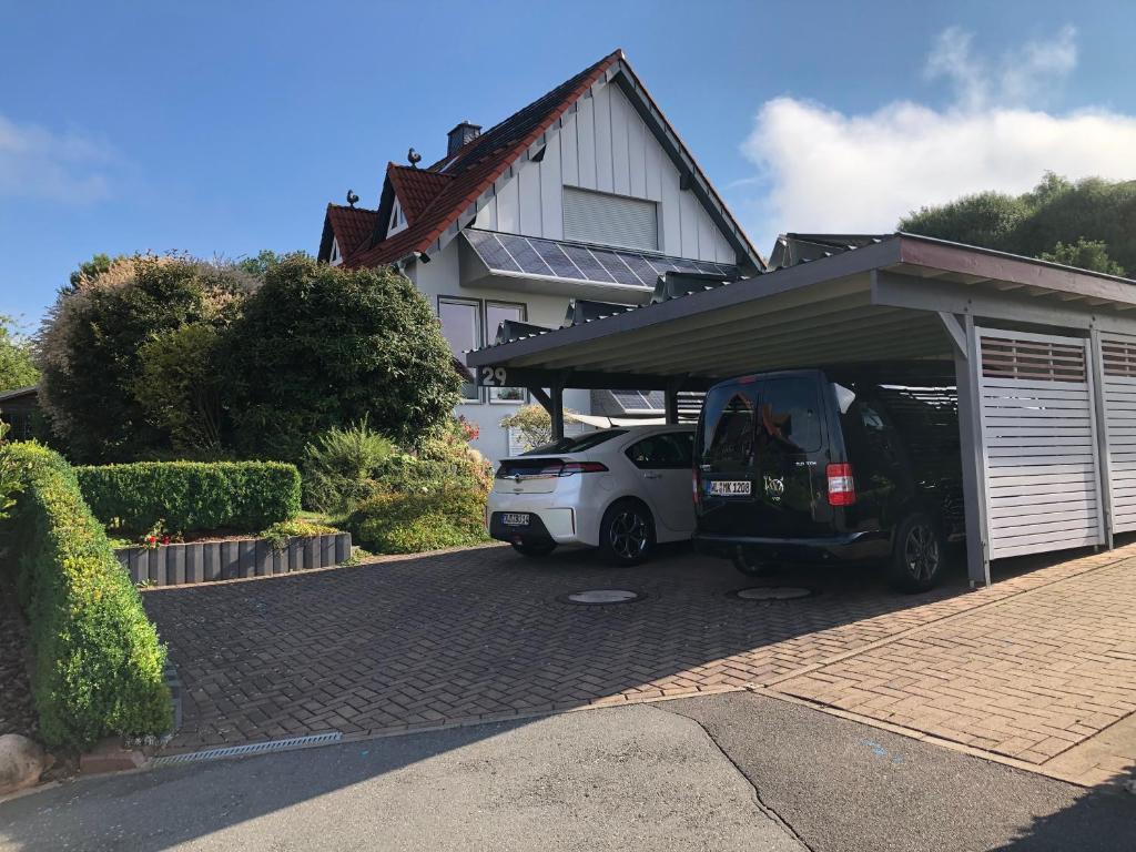 ein Auto, das in einer Garage neben einem Haus parkt in der Unterkunft Ferienwohnung Kuhn in Rhumspringe