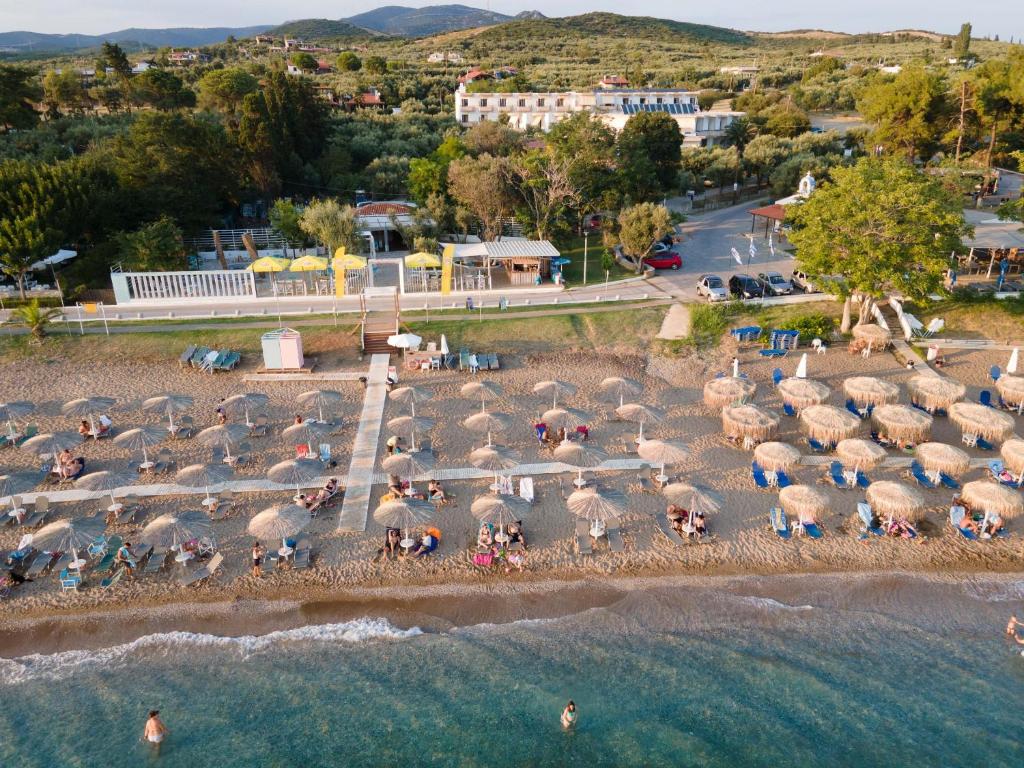 un grupo de personas en una playa con sombrillas en Klio Hotel, en Alexandroupoli