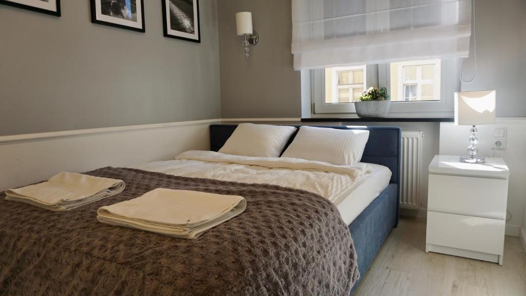 a bedroom with a bed with two towels on it at Apartament w samym sercu Opola 2 in Opole