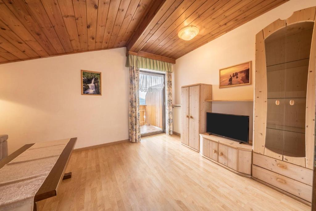 ein großes Wohnzimmer mit einem Flachbild-TV in der Unterkunft Residence Kronstein - Fewo 8 in Tisens