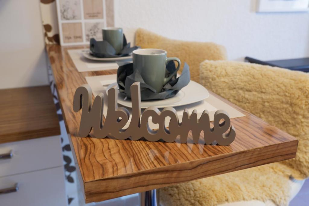 einen Tisch mit zwei Tassen und Platten darauf in der Unterkunft Ferienwohnung Rhein-Neckar in Waghäusel