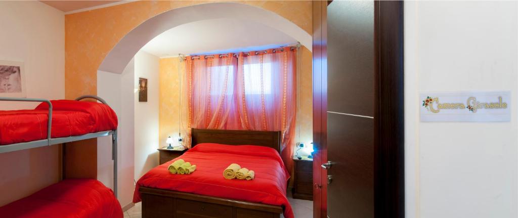 una camera con 2 letti a castello con lenzuola rosse di B&B Bovianum a Boiano
