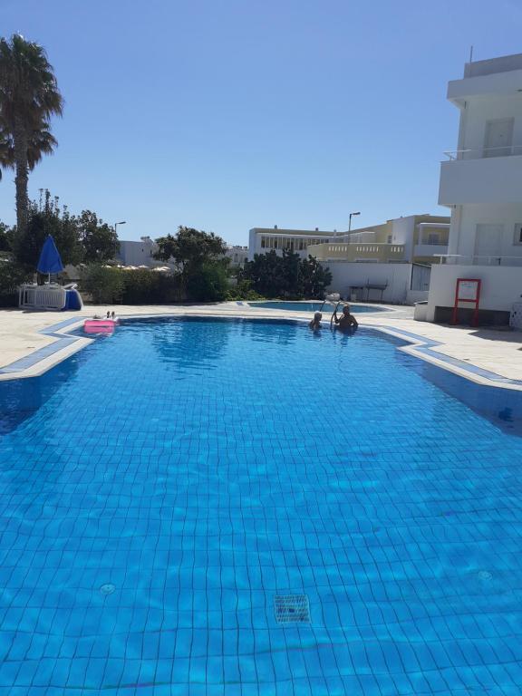 een groot blauw zwembad in een gebouw bij Antonis Hotel in Kefalos