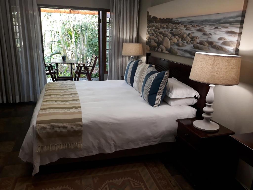 a bedroom with a large white bed with a window at The Sandpiper in St Lucia