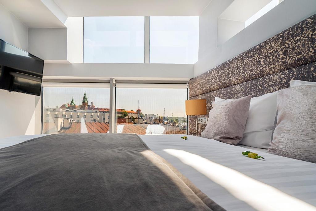 a bedroom with a large bed with a large window at Aparthotel Best Views in Krakow