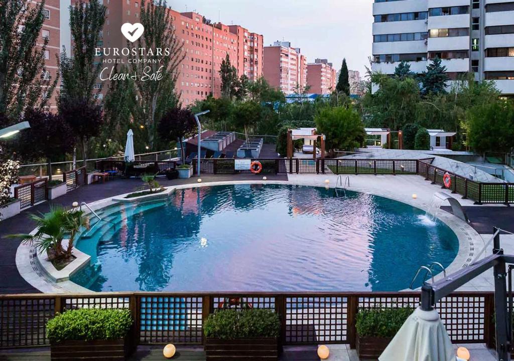 une grande piscine au milieu d'une ville dans l'établissement Eurostars Suites Mirasierra, à Madrid