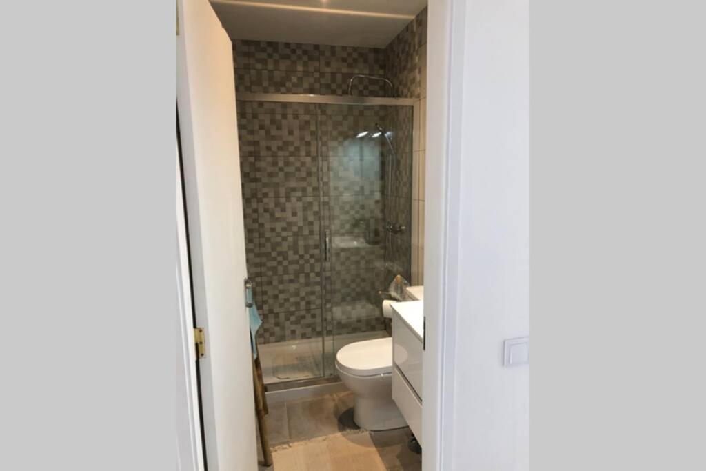 Un baño con inodoro, ducha y lavabo. en Milu house, en Faro