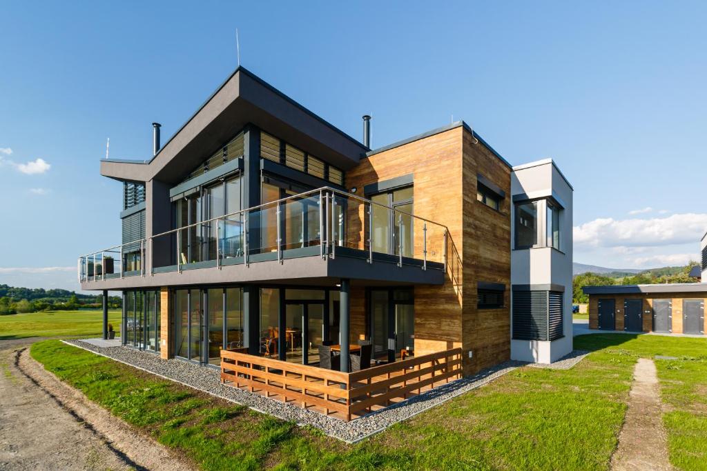 a modern house with a large deck and glass at Apartmán na golfu in Čeladná