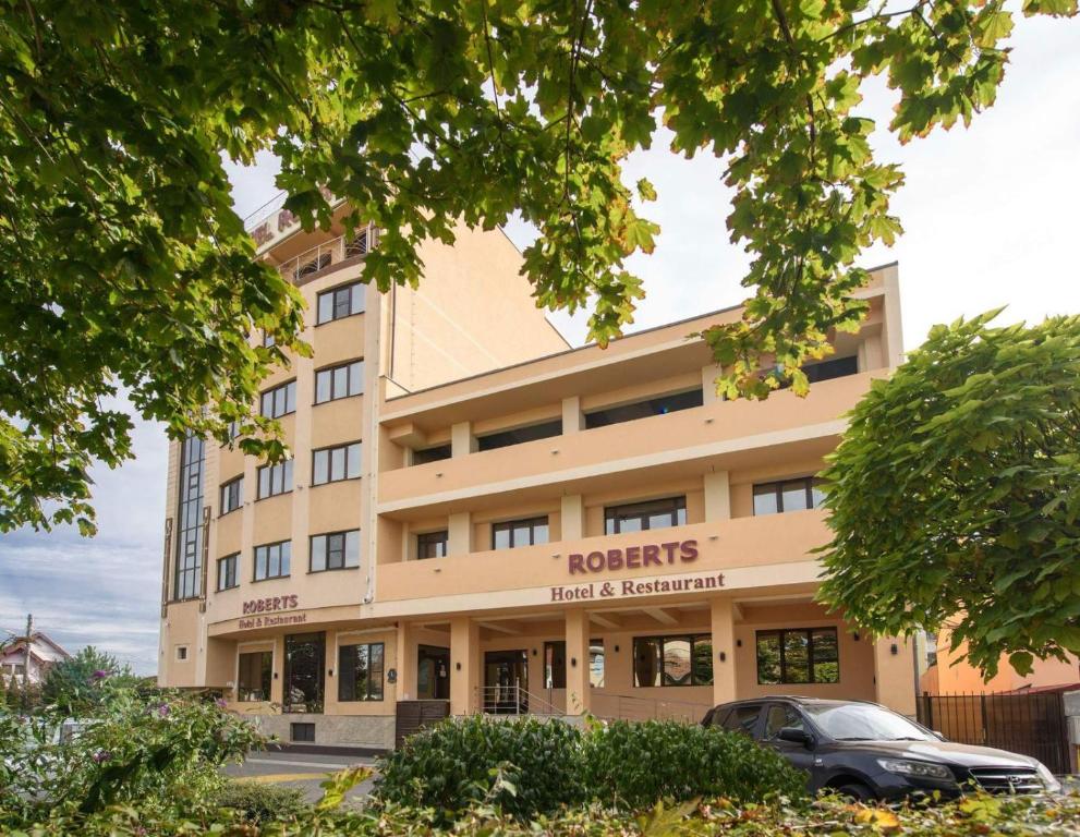 un edificio con un'auto parcheggiata di fronte di Hotel Roberts a Sibiu