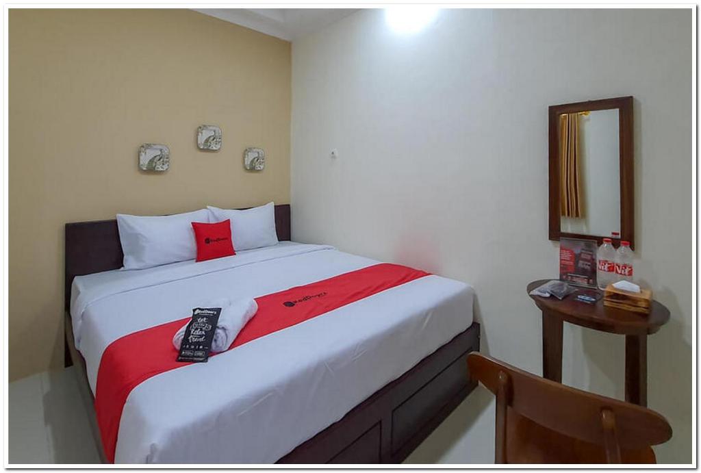 LaweanにあるRedDoorz Syariah near Solo Square Mallのベッドルーム1室(ベッド1台、リモコン付)