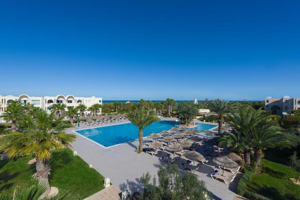 an aerial view of a resort with a swimming pool and palm trees at Iberostar Waves Mehari Djerba in Taguermess