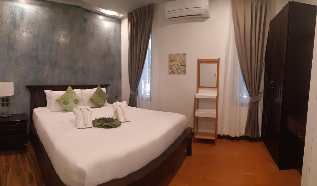 a bedroom with a large bed with white sheets at Cocoville Phuket - SHA Plus in Chalong 