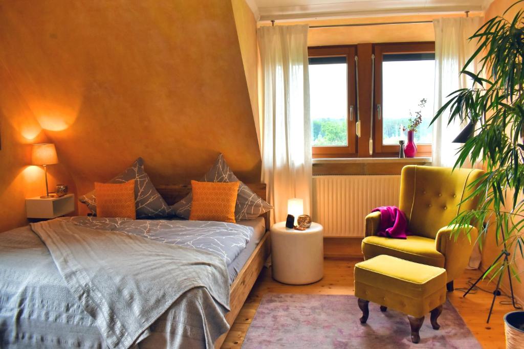 ein Schlafzimmer mit einem Bett, einem Stuhl und einem Fenster in der Unterkunft Mediterran-Skandinavisch - Outdoorwhirlpool ganzjährig in Burgthann