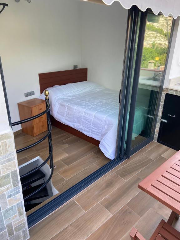 a bedroom with a bed and a sliding glass door at Casa Rural Los Amaneceres in Alcalá del Júcar