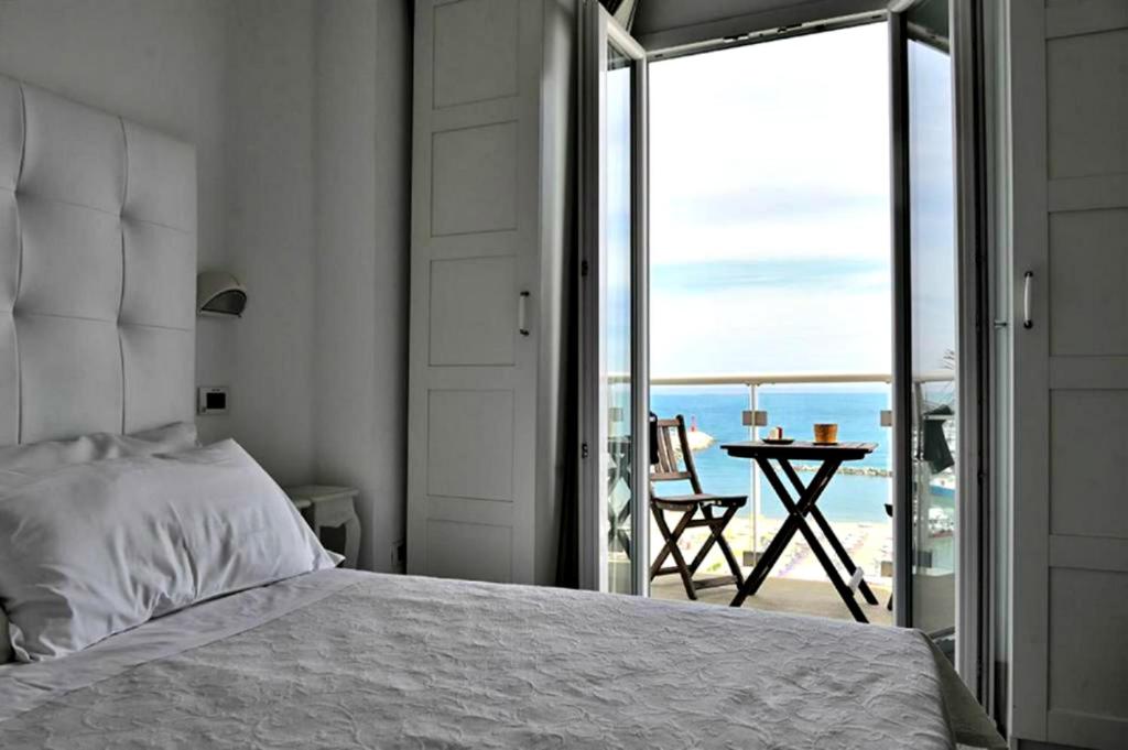 1 dormitorio con cama y vistas al océano en Hotel Thea & Residence, en Gabicce Mare