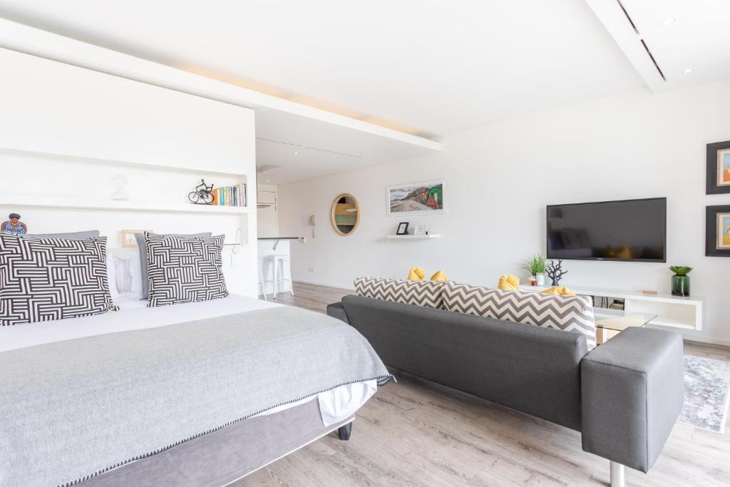 a bedroom with a large bed and a tv at 204 Juliette in Cape Town