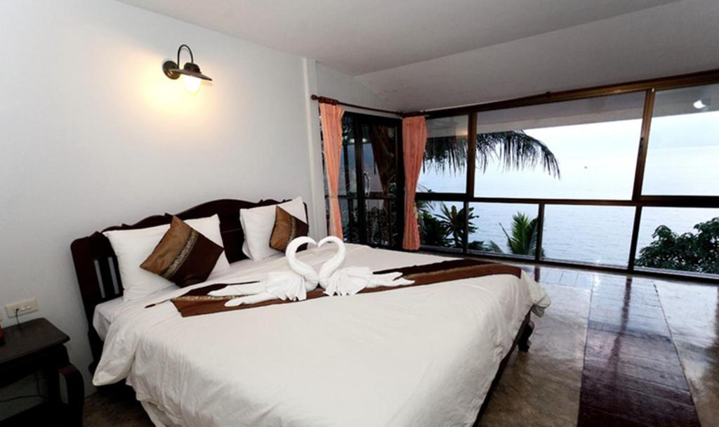 a bedroom with a bed with white birds on it at Chang Cliff Resort in Ko Chang
