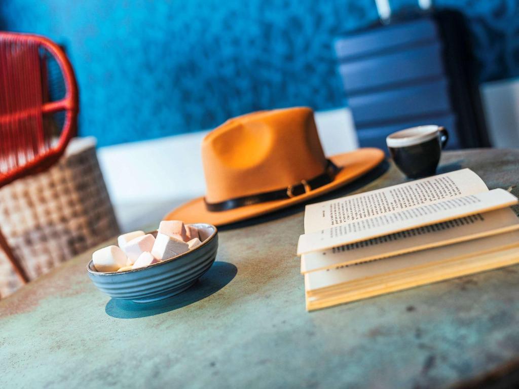eine Schüssel Marshmallows und einen Hut auf dem Tisch in der Unterkunft ibis Styles Le Treport Mers Les Bains in Mers-les-Bains