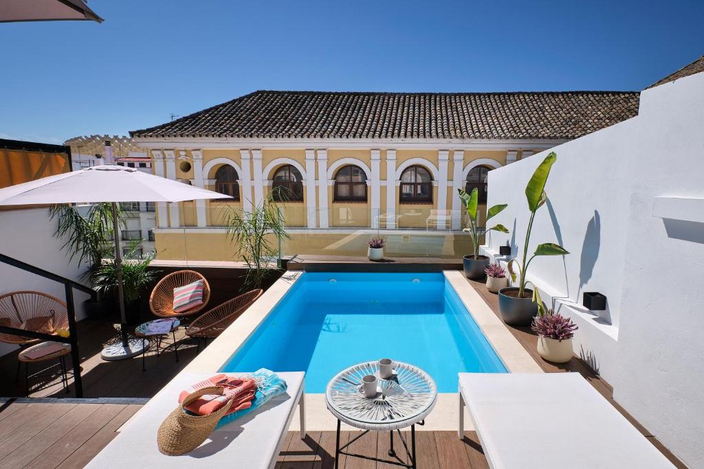 una piscina en el patio trasero de una casa en Sweet Sevilla Suites, en Sevilla